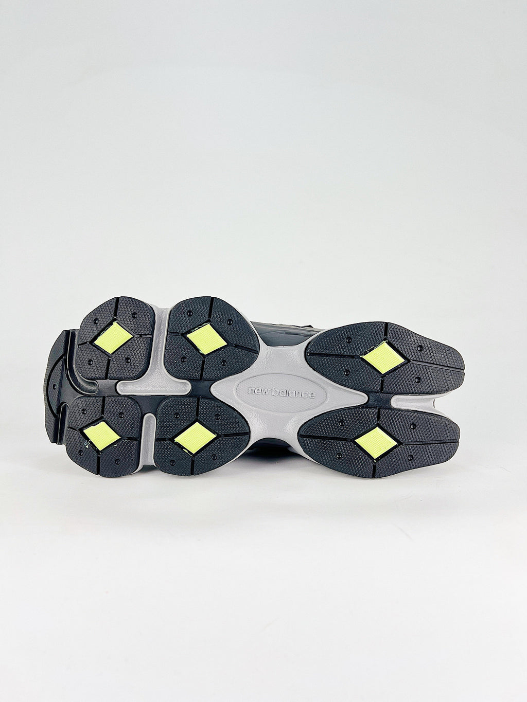 New Balance 9060 sneakers shown are in a black and cement colorway, often featuring a durable mesh and suede construction with Lime accents